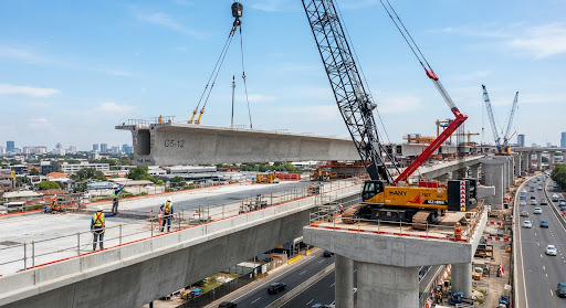Lattice boom crawler crane lifting a precast flyover girder